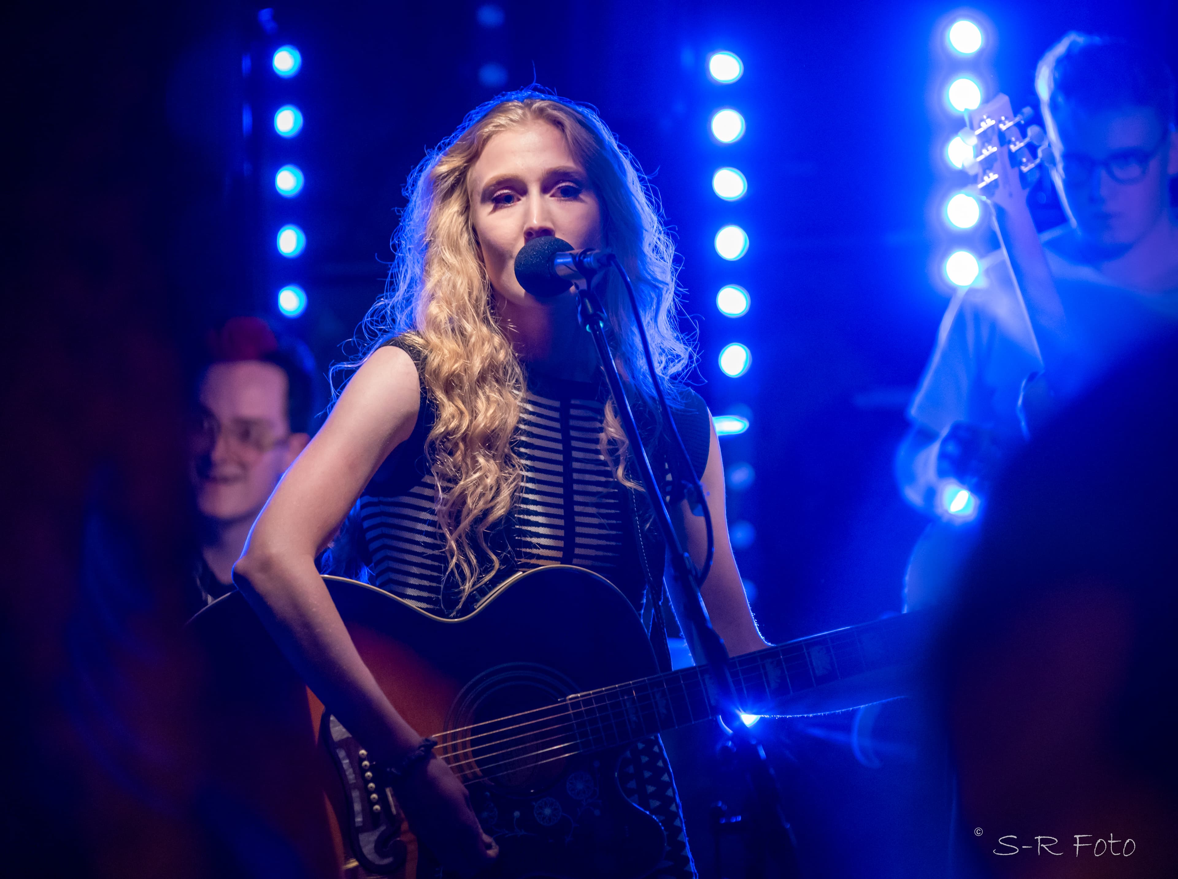 Ronja singig with her producer Jørunn in the background playing guitar.