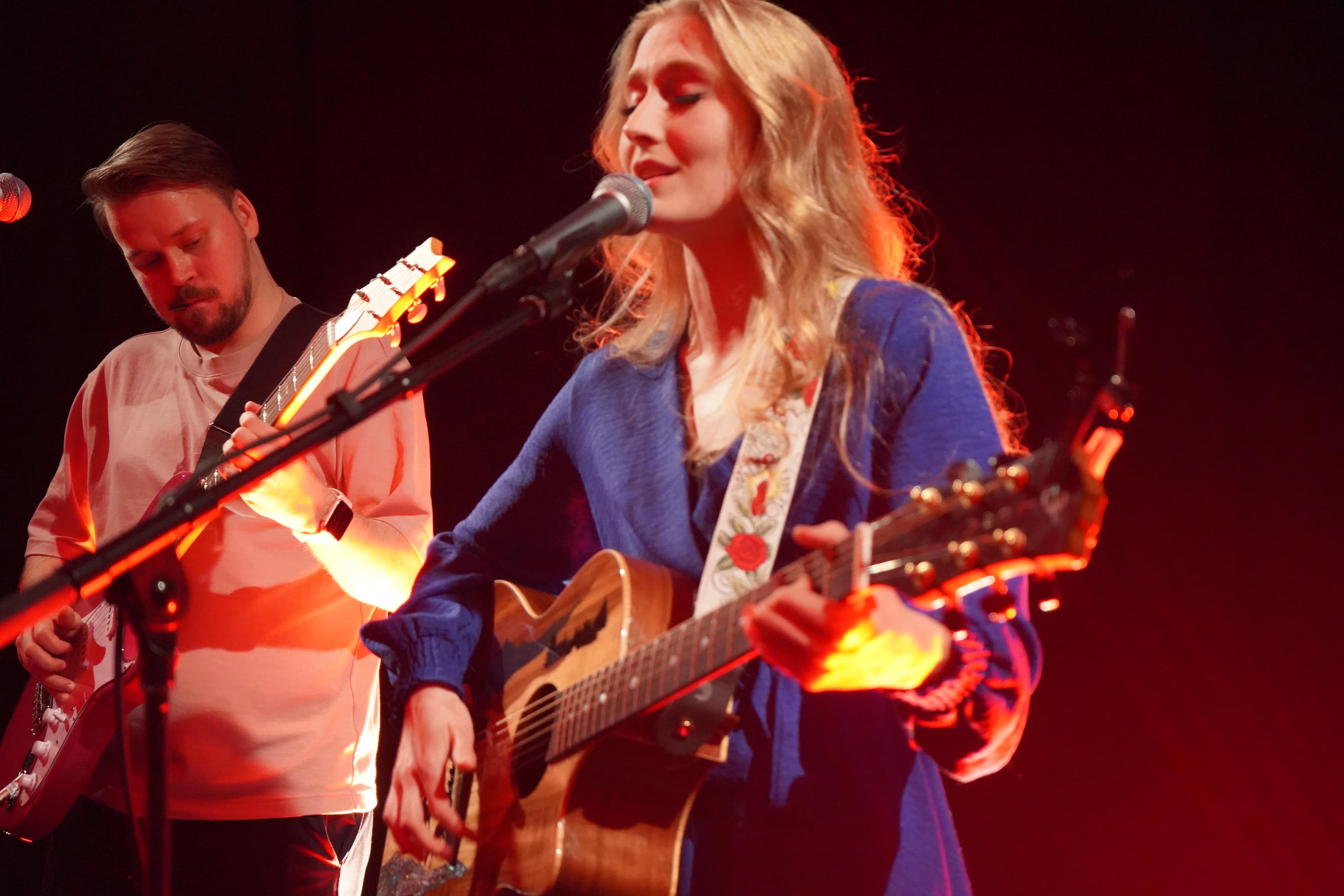 Ronja singig with her producer Jørunn in the background playing guitar.